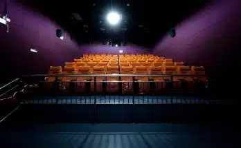 orange and white chairs with lights turned on in a stadium