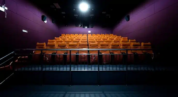 orange and white chairs with lights turned on in a stadium