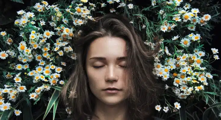 woman closing her eyes on white flower